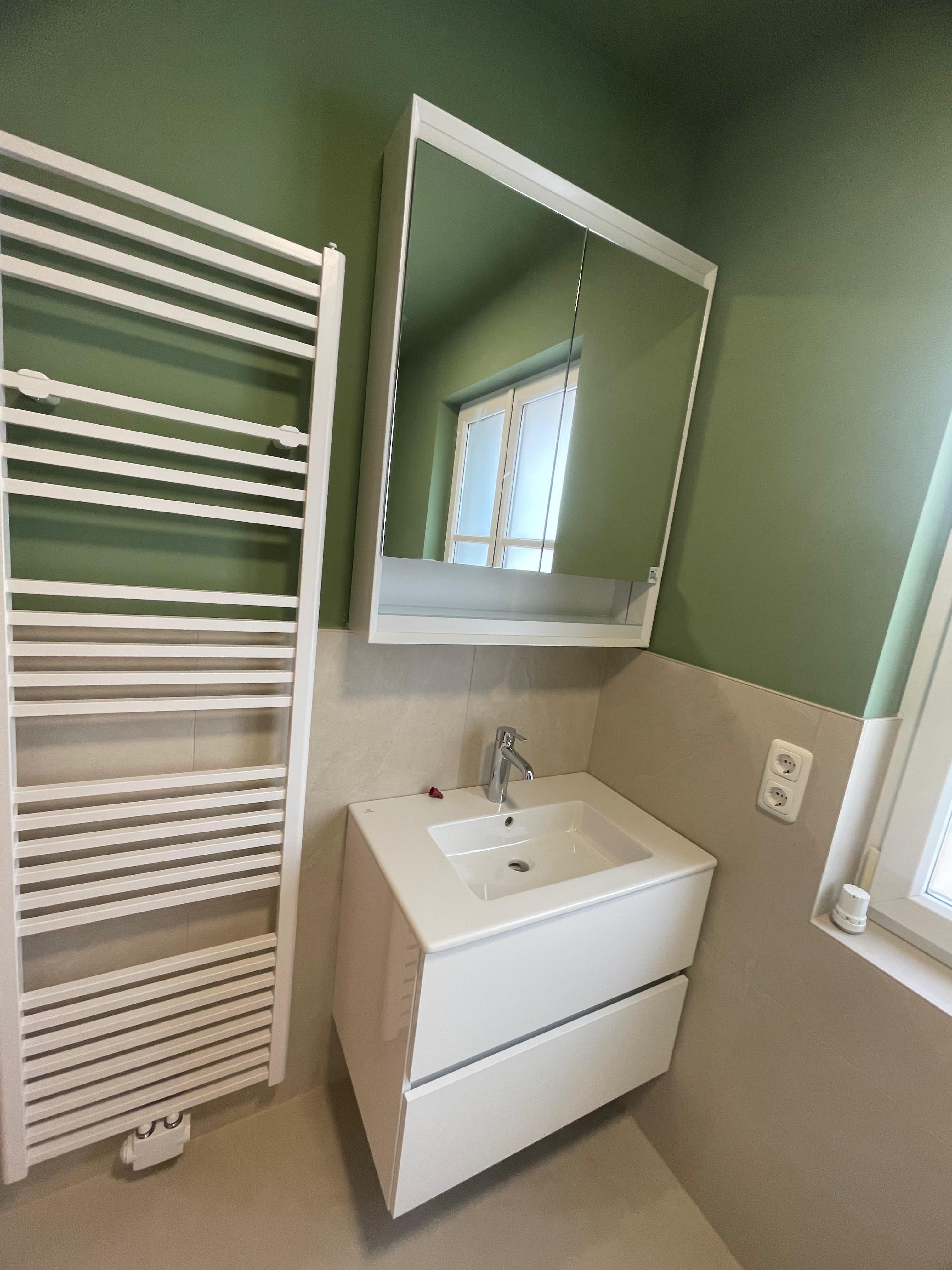 Kompaktes Badezimmer mit grünen Fliesen und modernem Waschbecken